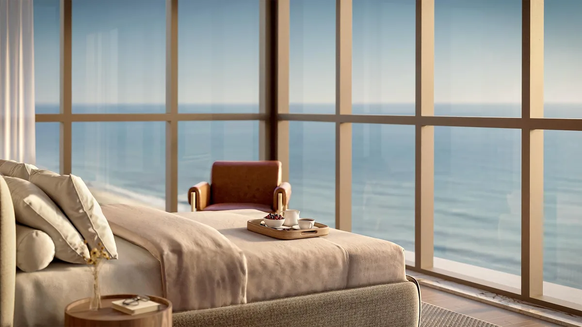 Quarto com cama arrumada e vista para o mar pela janela - Apartamento em Centro, Balneário Piçarras