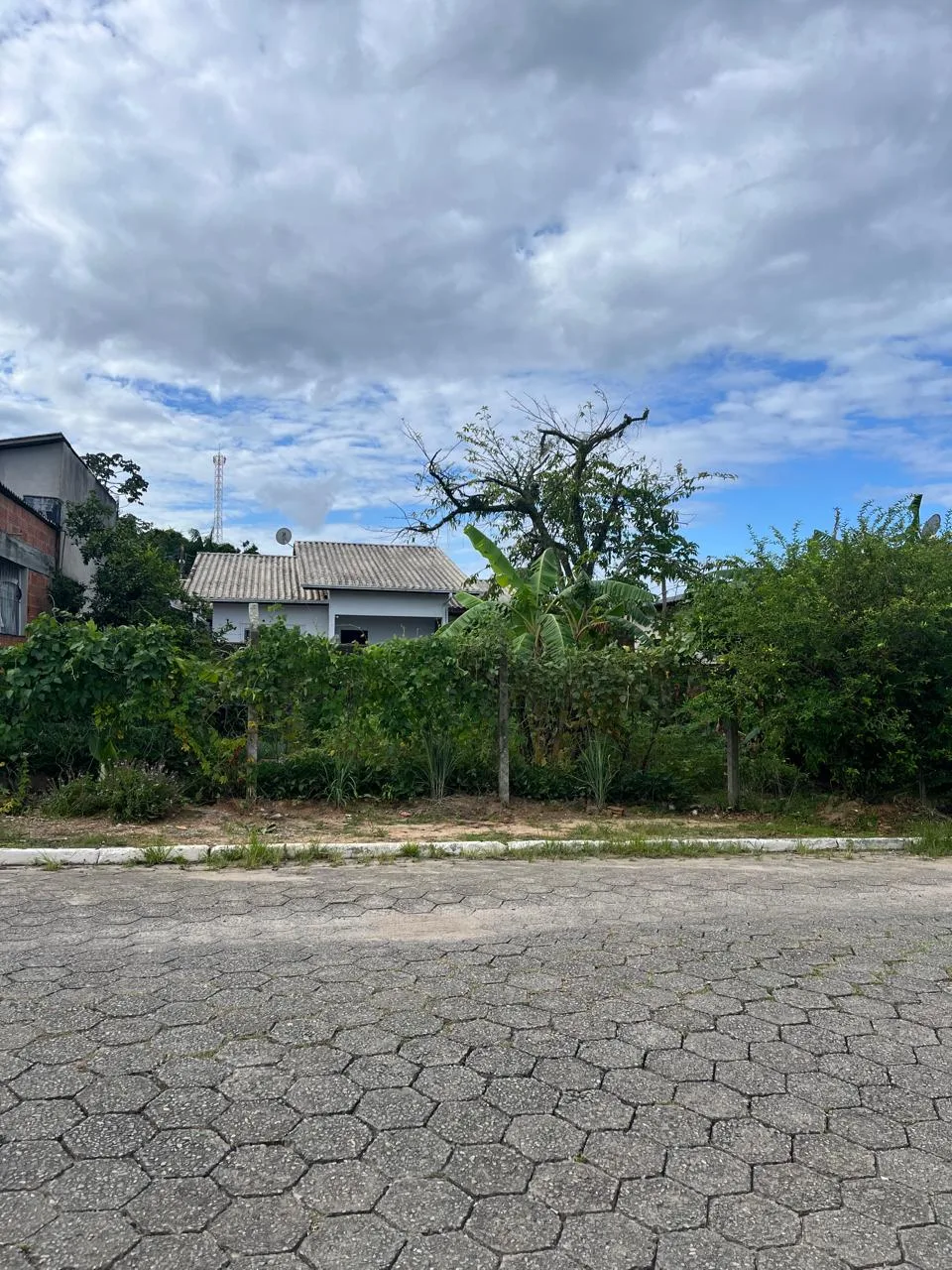 Fachada de casa com muro de vidro e jardim em Balneário Piçarras/SC